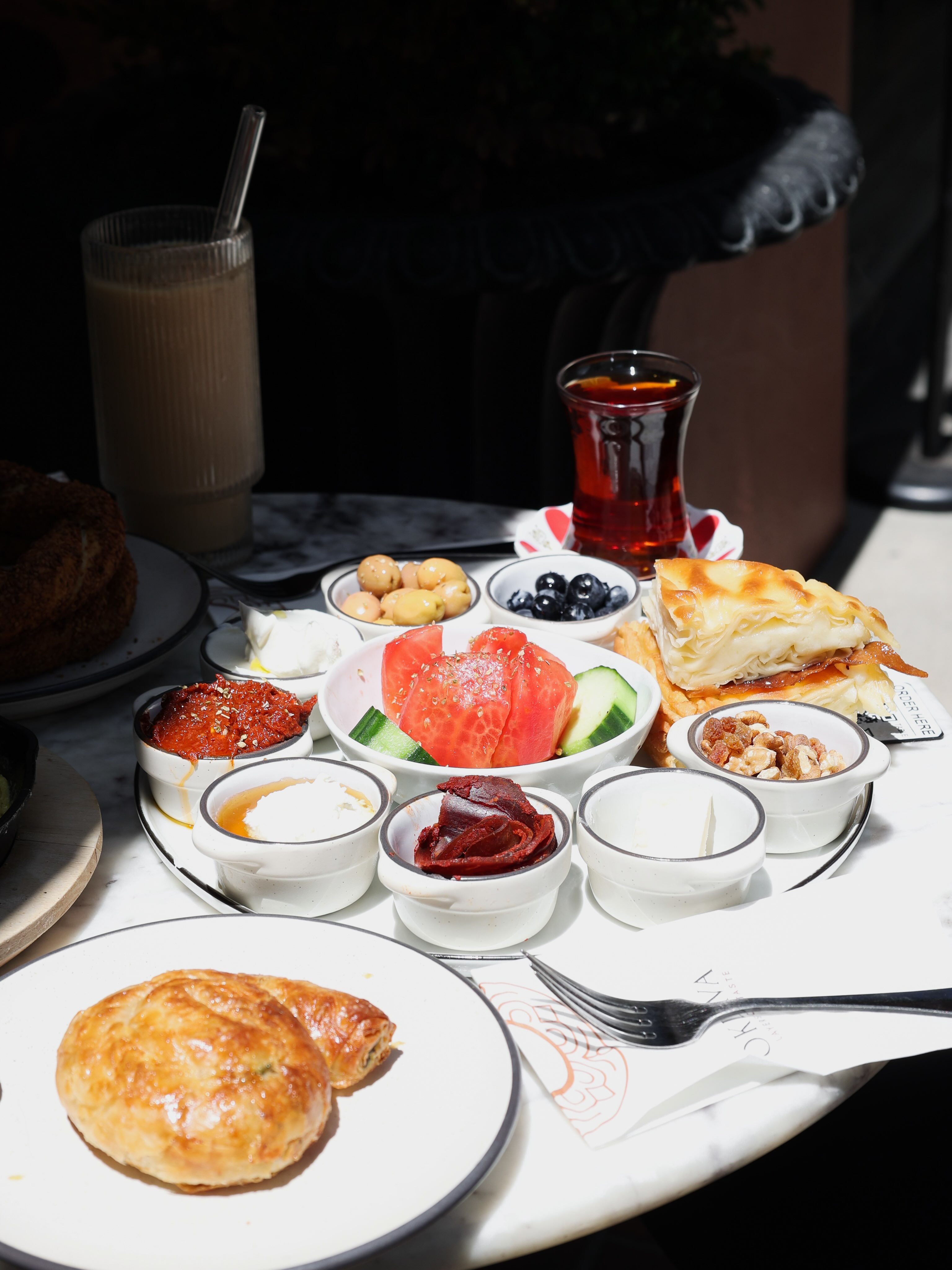 Turkish breakfast spread with tea, olives, cheeses and borek