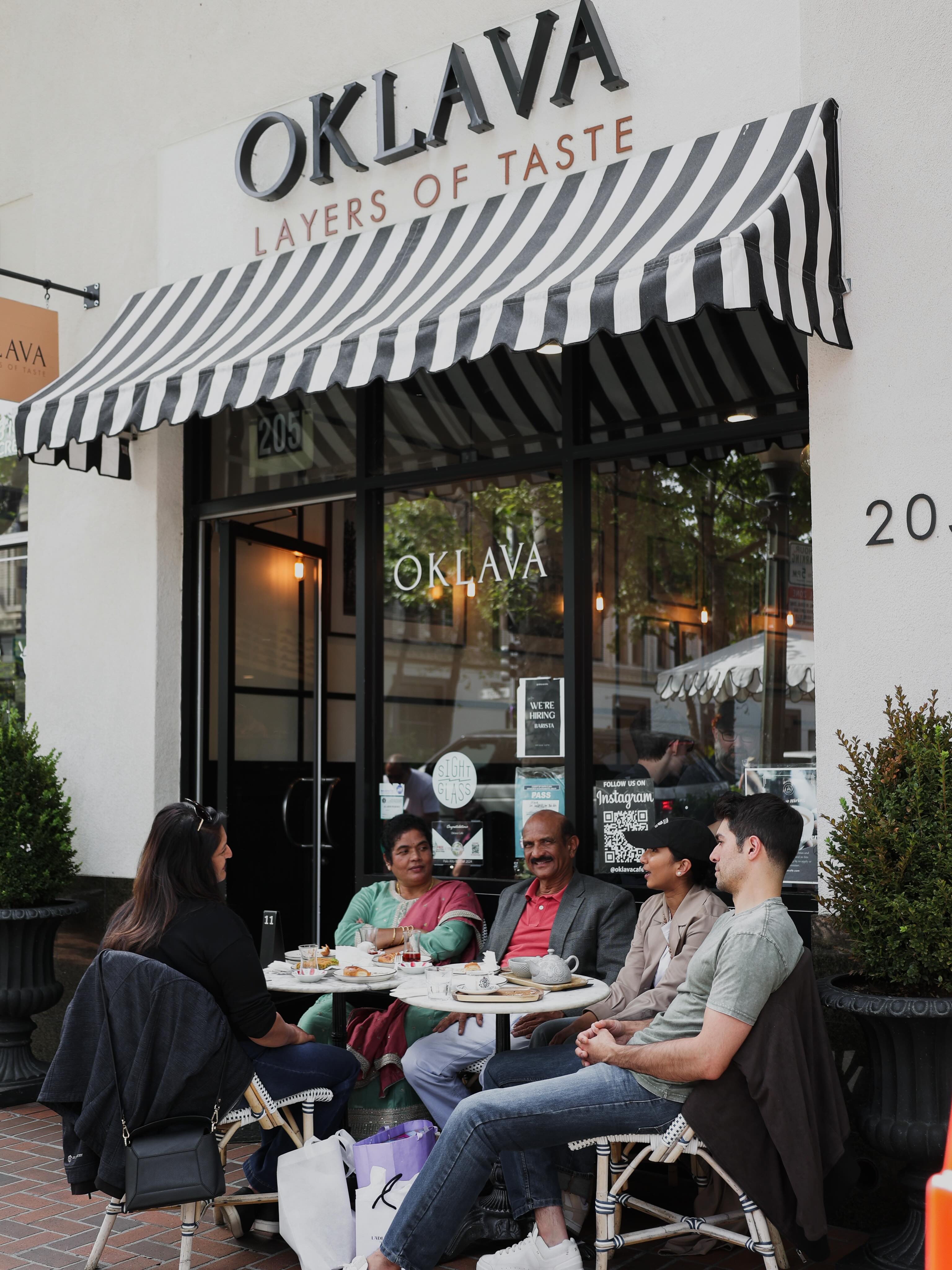 Oklava storefront with the striped awning and outdoor seating