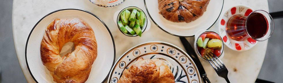 Wide table spread of croissants and Turkish tea