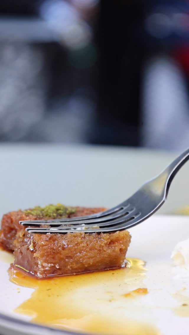 Fork lifting a bite of syrupy Turkish dessert