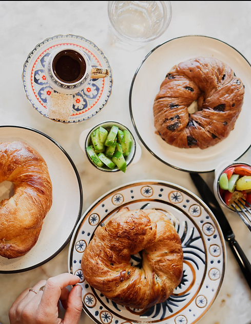 Overhead view of croissants, Turkish coffee and small plates