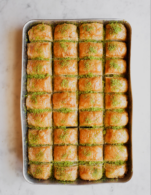 Tray of freshly cut pistachio baklava rolls